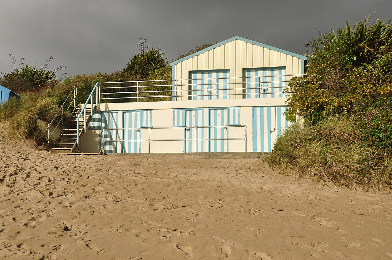 A striped beach hut on the sand at Abersoch